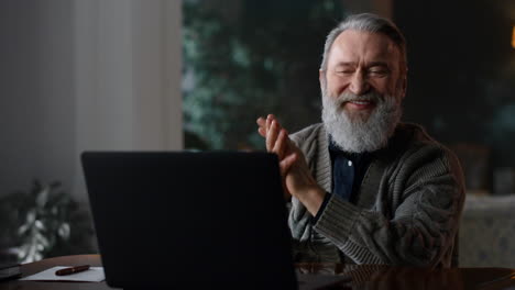Happy-gentleman-having-video-call-laptop-home.-Senior-man-using-computer-indoors