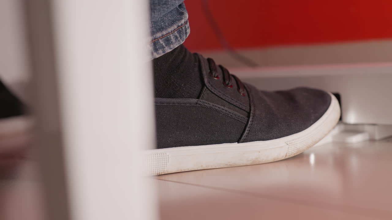 검은 신발과 청색 청바지를 입은 발이 피아노 페달에 서서히 발을 는 클로즈업, 음악가의 발과 악기 사이의 상호 작용의 세부 사항을 포착합니다.