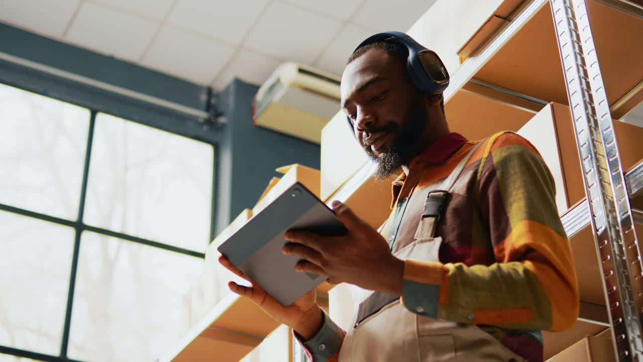 Warehouse worker using tablet to manage inventory