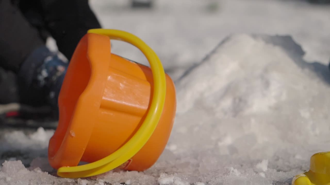 눈 과 플라스틱 버 을 가지고 놀고 있는 아이