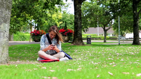 Student-Sitzt-Auf-Dem-Rasen-Und-Telefoniert