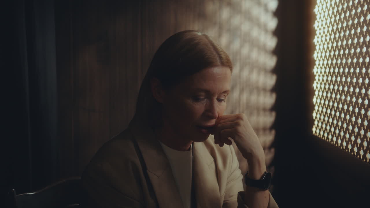 Elderly Woman Speaking in Dimly Lit Confessional Booth