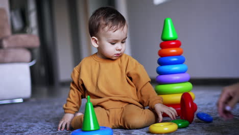 niño pequeño jugando con anillos apilados