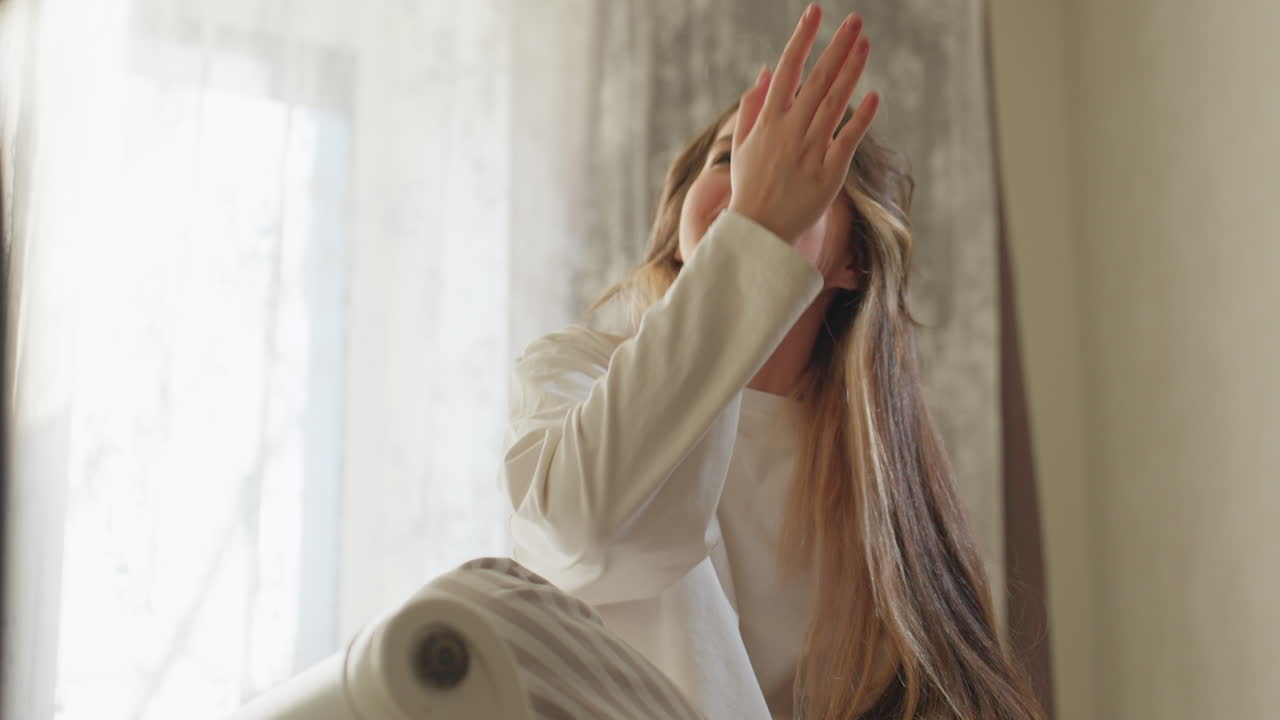침대에서 편안한 줄무늬 파자마를 입고 친구와 이야기를 나누며 즐겁게 웃는 학생의 낮은 앵글 시점, 커튼을 통해 들어오는 자연광이 쾌활한 표정과 태평한 분위기를 강조해요