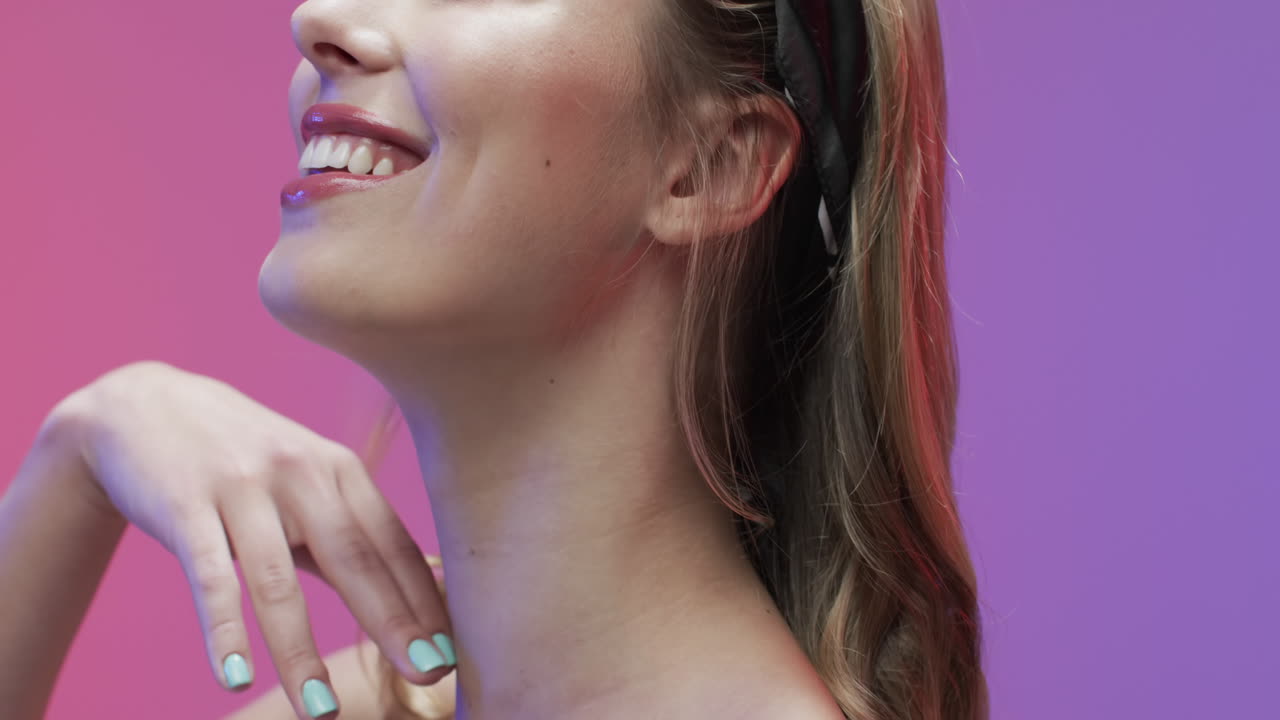 retrato de una mujer caucásica sonriente con el cabello rubio tocando su cuello, copia espacio, cámara lenta