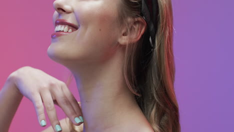 retrato de una mujer caucásica sonriente con el cabello rubio tocando su cuello, copia espacio, cámara lenta