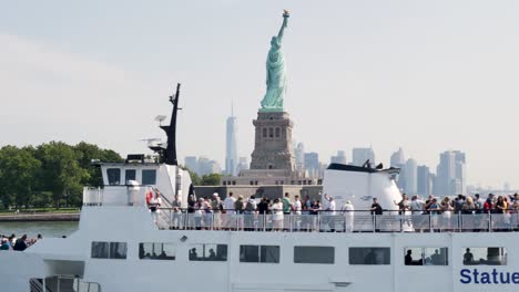 slow motion landscape of cruise ship ferry with people tourists at the iconic statue of liberty monument in new york city skyline cbd usa america travel tourism