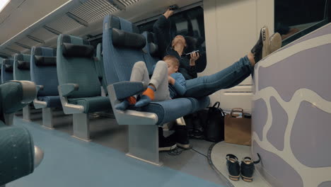 madre e hijo pasando el tiempo con electrónica durante el viaje en tren