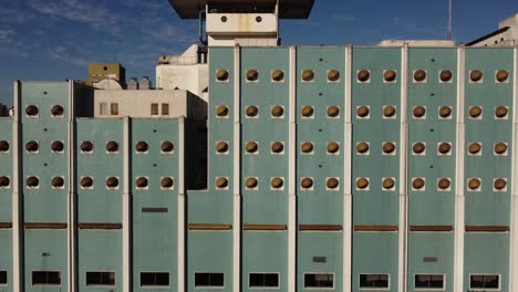 Aerial-view-of-symmetrical-blue-front-view-of-Naval-Hospital-of-Buenos-Aires-with-circular-windows-during-sunny-day