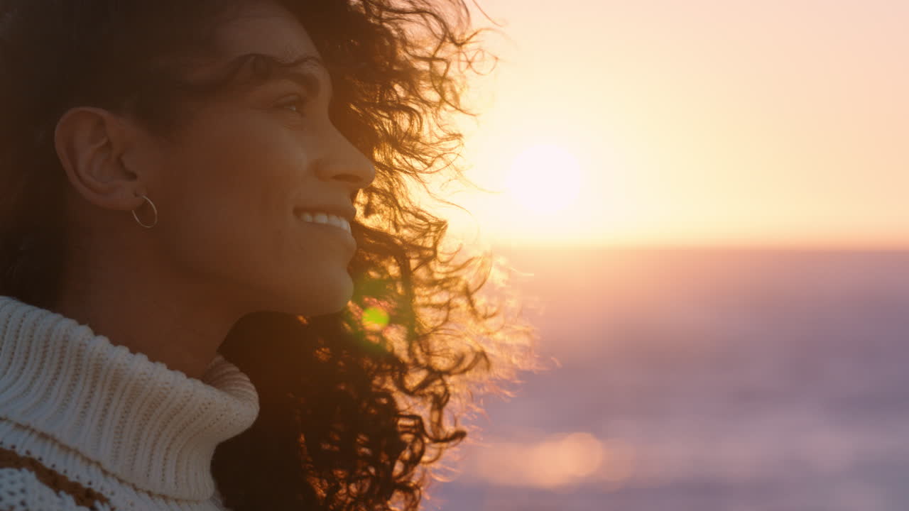 retrato de una hermosa mujer hispana disfrutando de la tranquilidad de la playa al atardecer explorando la atención contemplando la espiritualidad con el viento soplando el cabello