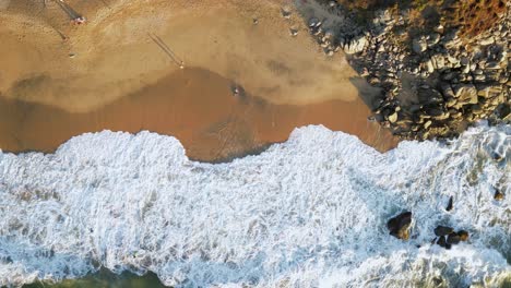 A-Se-Acuesta-En-La-Playa-Y-Hace-Un-ángel-De-Arena-Mientras-Lo-Lava-Con-Las-Olas