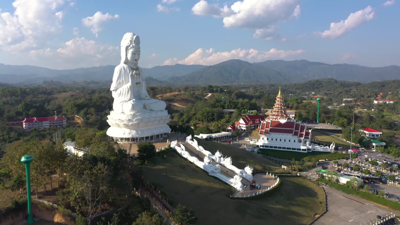 increíble drone aéreo al revés de wat huay pla kang gigante blanca gran estatua y templo pagoda con montañas y terreno espacio en chiang rai, tailandia