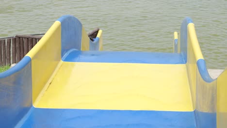 pov mirando hacia abajo un colorido tobogán de agua amarillo y azul en un parque acuático