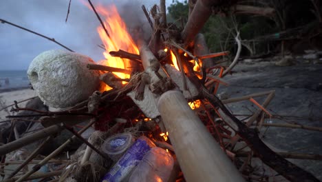 fire on the beach with plastic parts and garbage