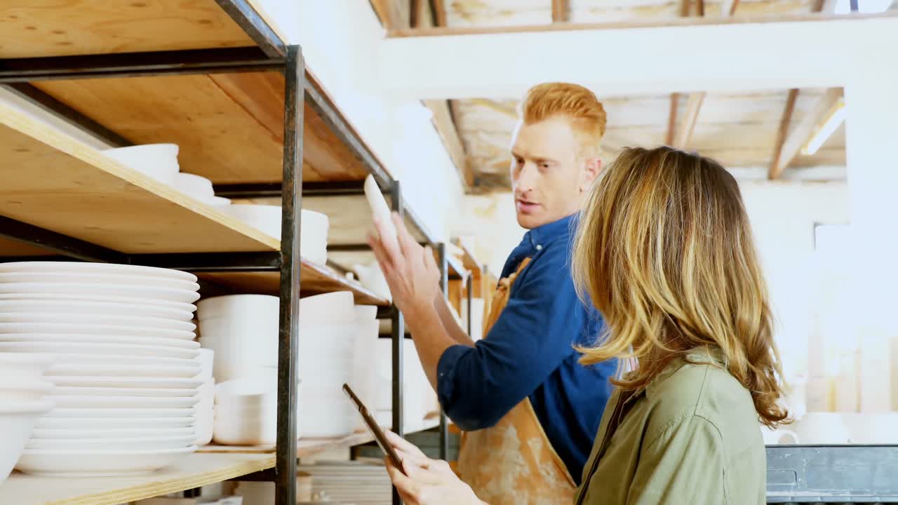 hombre y mujer alfarero usando tableta digital 4k