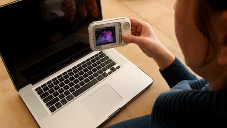 Woman-sitting-at-kitchen-table-using-laptop