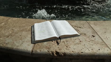 Holy-Book-by-a-Peaceful-Water-Fountain-Background-in-Slow-Motion