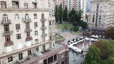 4K-Arial-Drone-Footage-of-beautiful-building-complex-of-Central-Kiev-Apartments-on-Khreschatyk-Street-along-with-the-fountain-in-the-front-surrounded-by-restaurants-and-cafe's