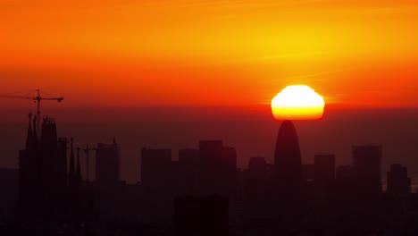 Timelapse-De-La-Salida-Del-Sol-En-El-Mar-Mediterráneo-Detrás-De-Las-Glorias-De-Torre-Agbar-En-Barcelona-Con-Sagrada-Familia