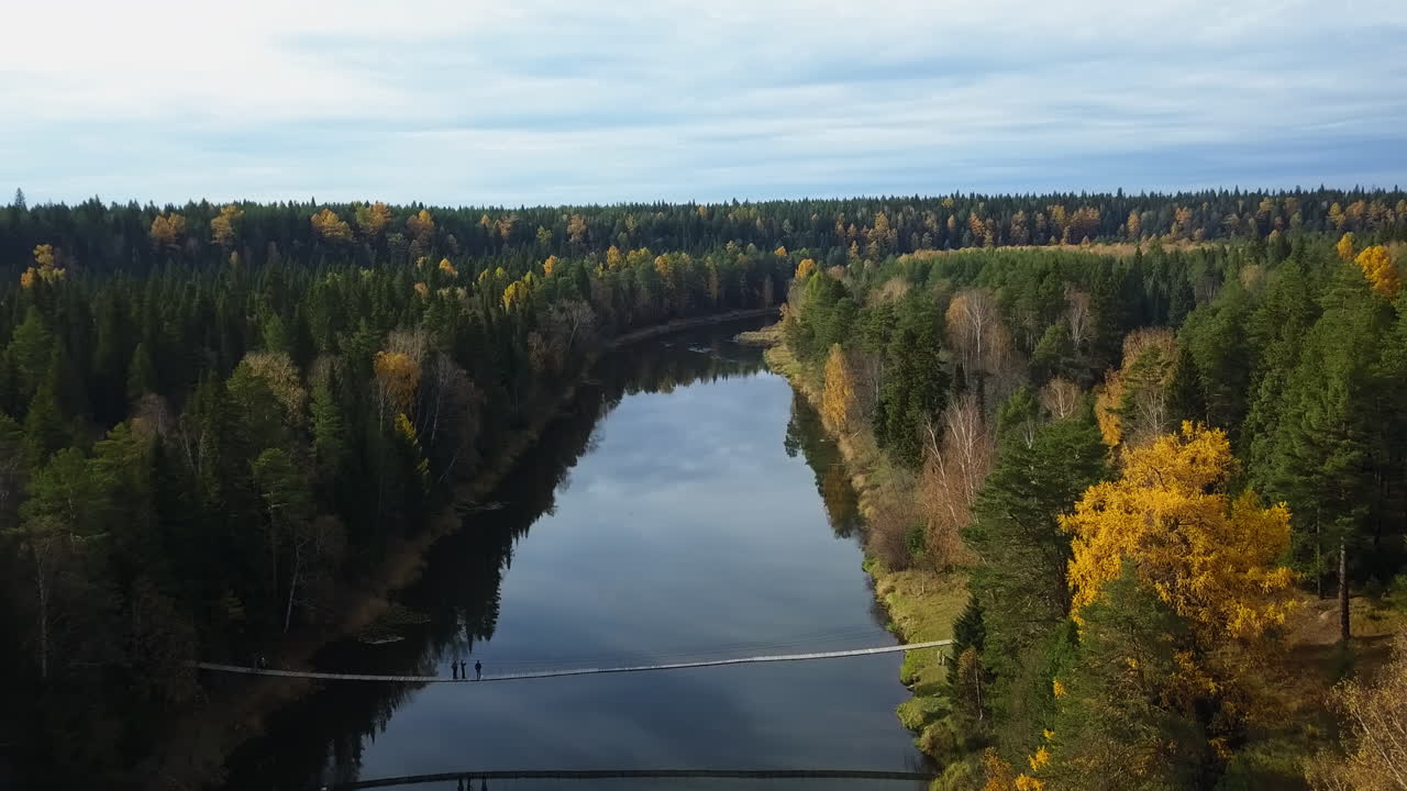 Syksyinen jokimaisema kävelysillalla