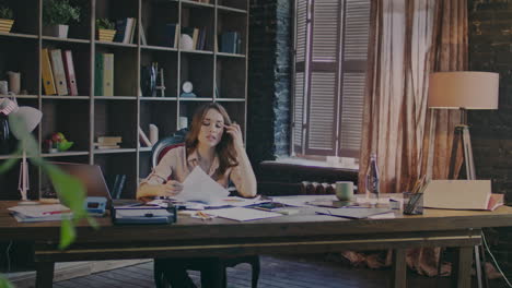 Concentrated-businesswoman-sitting-at-table-and-carefully-reading-contract