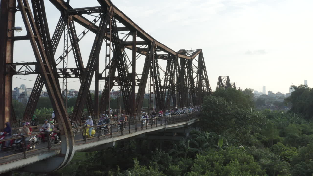 Thousands of motorbikes at rush hour cross Long Bien bridge in Vietnam's capital, Hanoi. Th historic cantilever bridge was constructed by Gustave Eiffel.