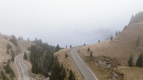 Fliegen-Durch-Nebliges-Wetter-über-Serpentinenstraße-In-Der-Landschaft-Der-Bucegi-Berge,-Rumänien