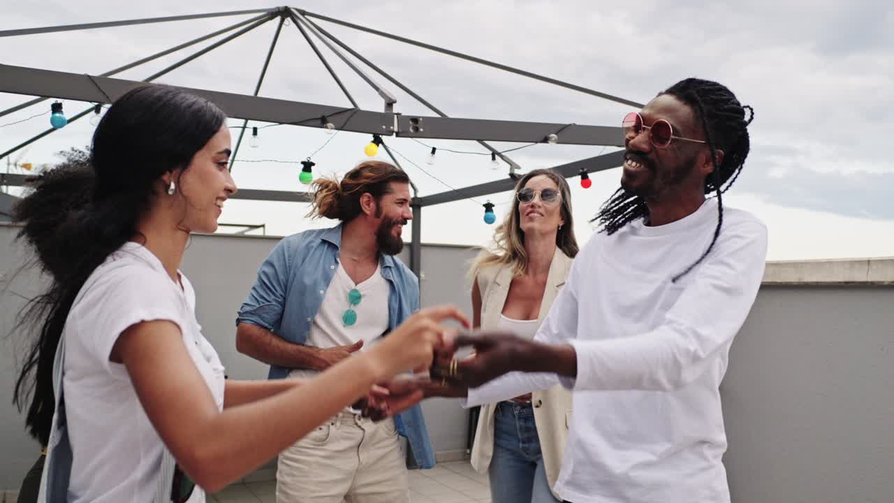 Group of friends dancing at a rooftop party