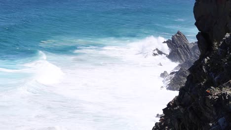 las olas golpean la orilla rocosa con un fuerte chorro