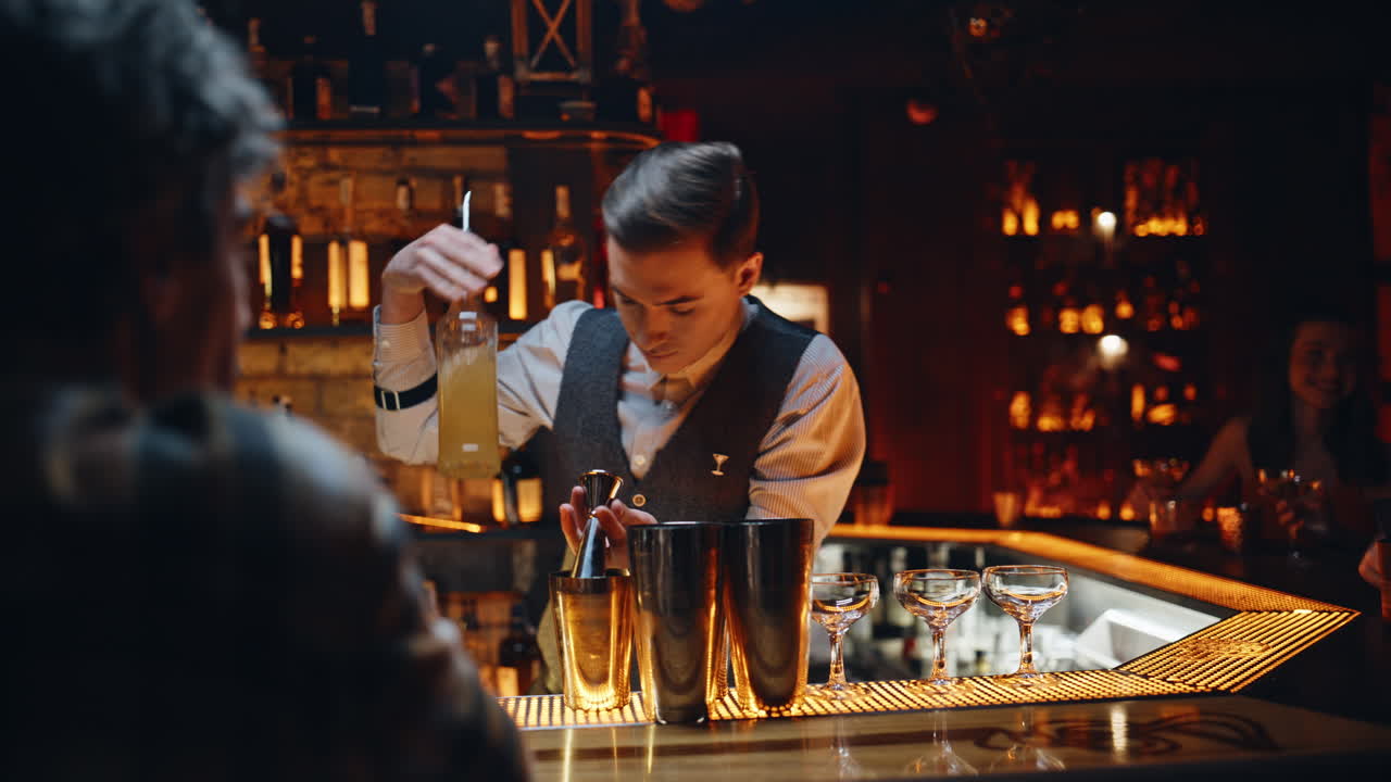 Primo piano di un barista elegante che prepara un cocktail in un night club moderno. Barman serio