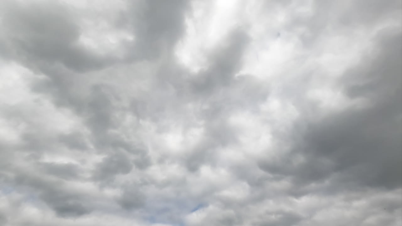 Grey cumulus cloudscape totally covering the sky. Rainy dramatic clouds formation. Timelapse.