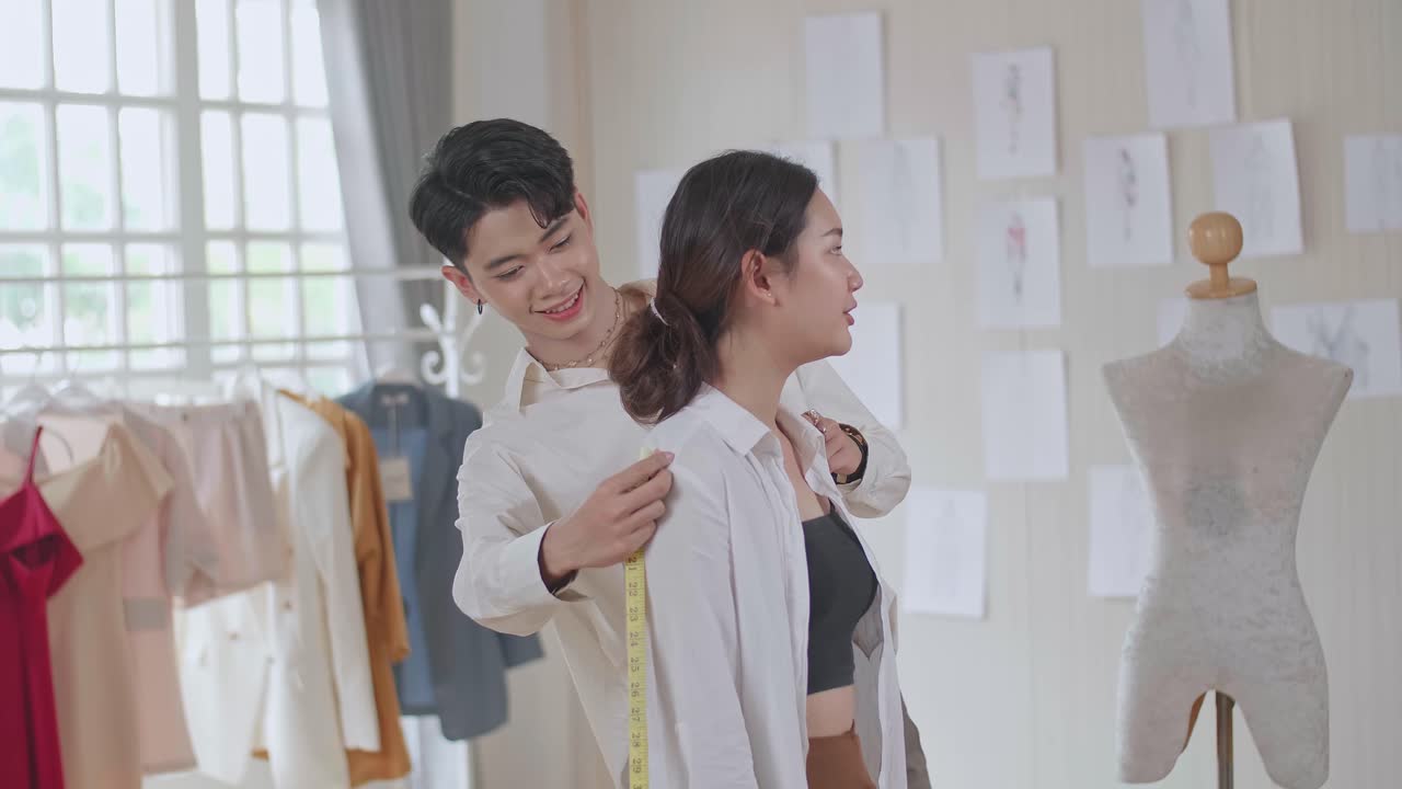 Man Tailor Takes Measures With Female Models. Fashion Designer Sews A Costume For The Model