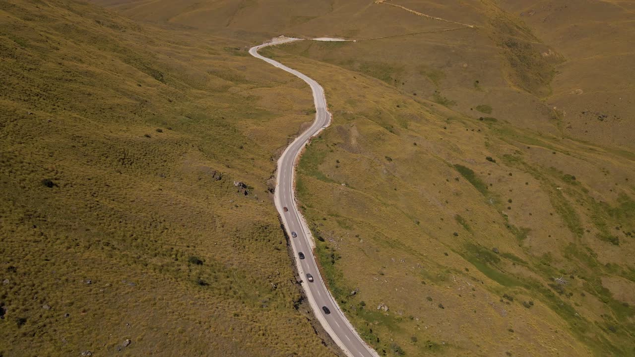 autos conduciendo por el paso de montaña cardrona en otago, nueva zelanda - inclinación aérea hacia arriba