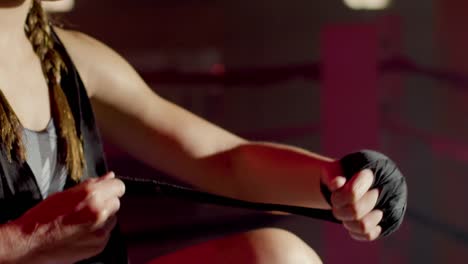 close up of an unrecognizable caucasian sportswoman  wrapping hands with boxing bandages at gym