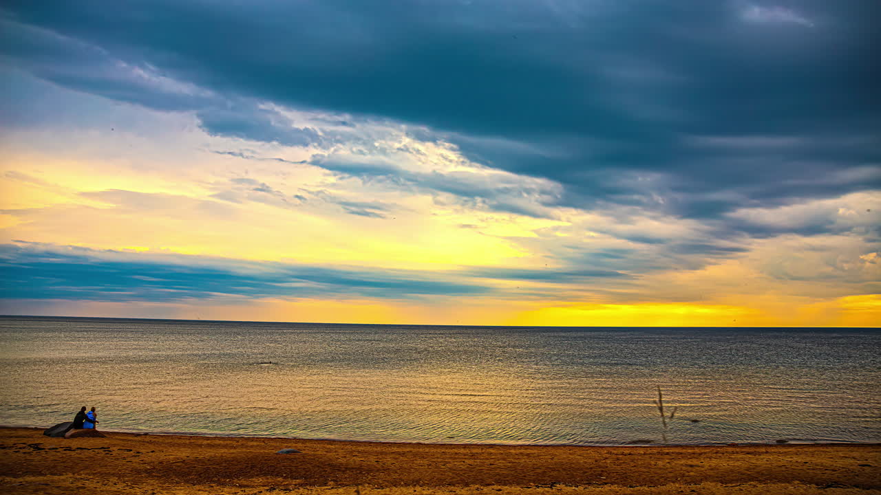 고립 된 해변 에서 황금빛 의 해가 지는 것 을 지켜보는 부부 의 시간 흐름