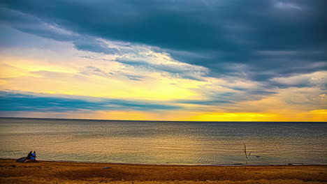 timelapse of a couple watching the golden sunset on an isolated beach