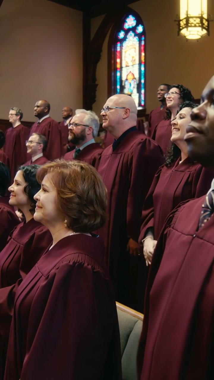 Vertical video: Clapping man on right performing as camera shifting out in church robes, copy space