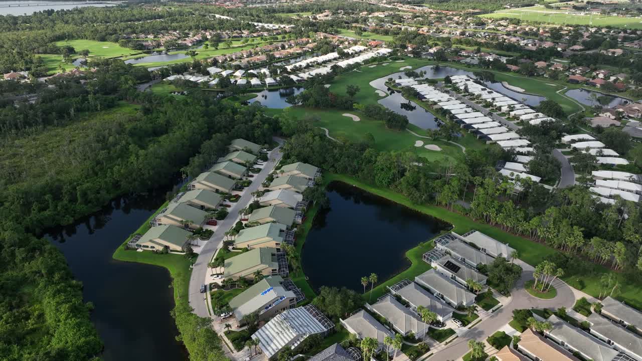Residential community in Bradenton, Florida. Cluster of homes with modern architecture set alongside serene pond. outdoor living spaces and lush landscaping, creating a harmonious environment. Aerial