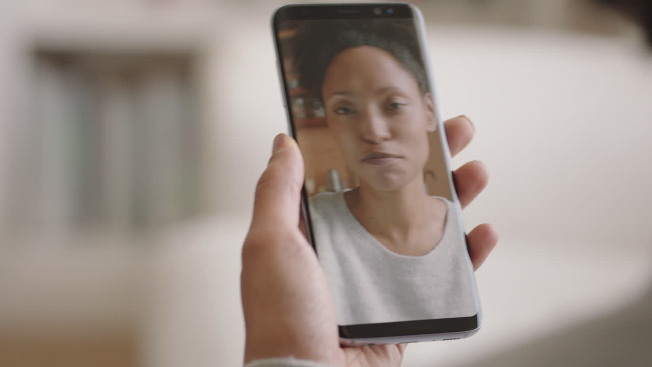 mujer joven teniendo video chat usando teléfono inteligente en casa hablando con un amigo disfrutando de la conversación compartiendo estilo de vida en el teléfono móvil orientación vertical 4k metraje