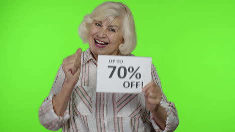 Senior-grandmother-showing-Up-To-70-percent-Off-inscription-sign,-rejoicing-discounts.-Chroma-key