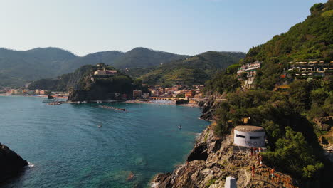 在意大利的portovenere村,白天在水中航行的船只在海中环绕着小房子和度假村的悬崖顶部景色