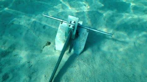 Danforth-anchor-secure-in-sand-in-tropical-blue-water-with-light-rays-shining-through