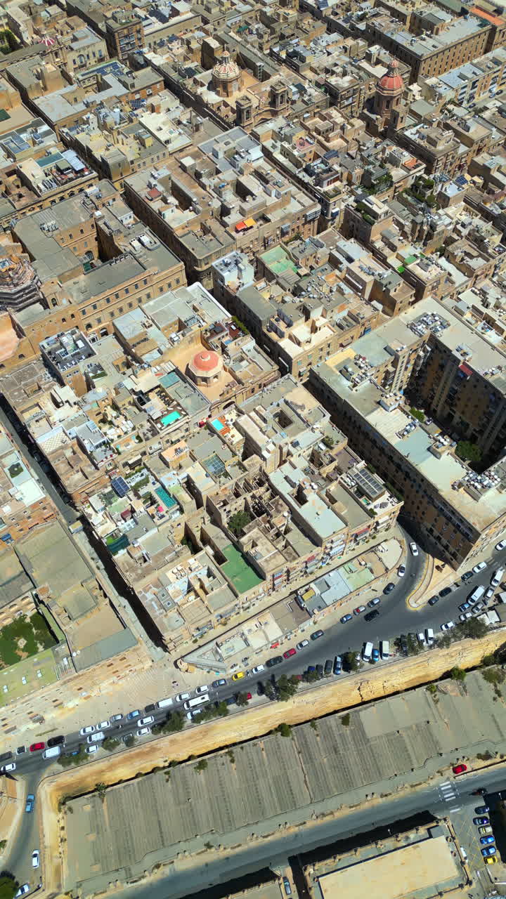 Aerial drone view of the walled city of Valletta, Malta, surrounded by the Mediterranean sea in daylight. Vertical