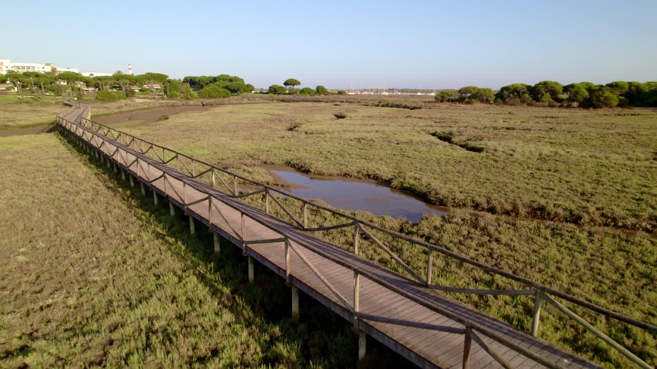 pasarela de madera entre las llanuras de lodo durante la marea alta al atardecer