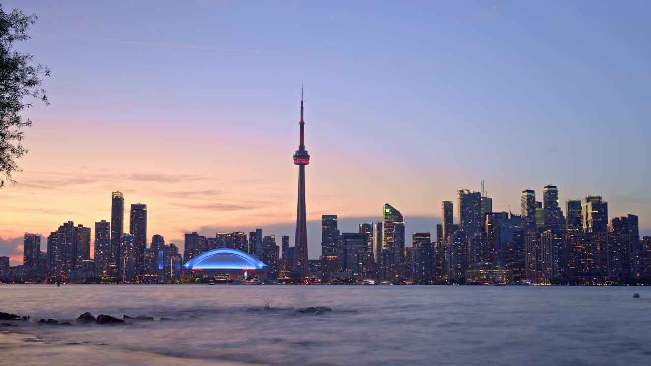 Lo skyline di Toronto e la CN Tower passano dal tramonto alla notte mentre le luci della città illuminano lo skyline, Time-lapse.