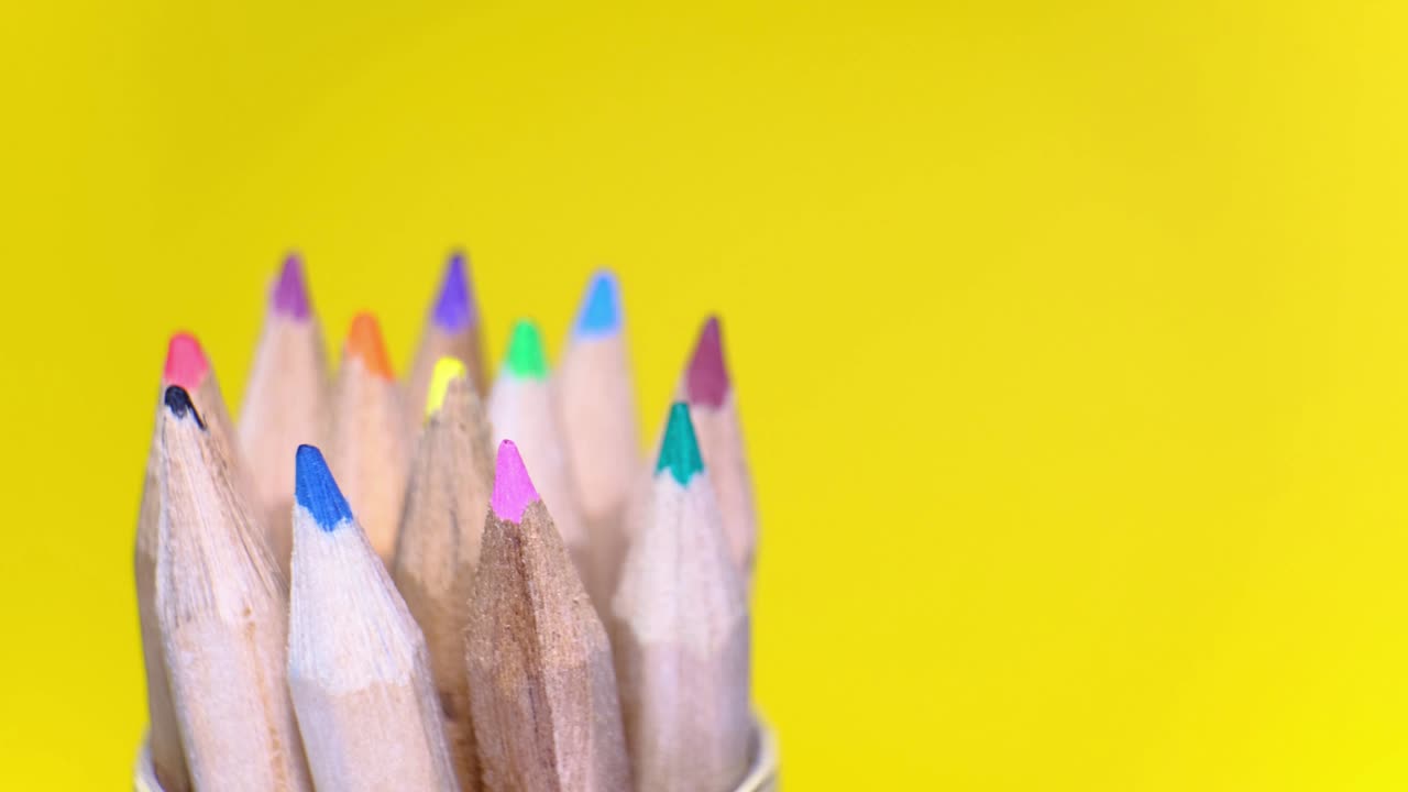 conjunto de lápices de madera de colores en diferentes colores que giran sobre un fondo amarillo. objeto aislado con espacio de copia. concepto de regreso a la escuela.