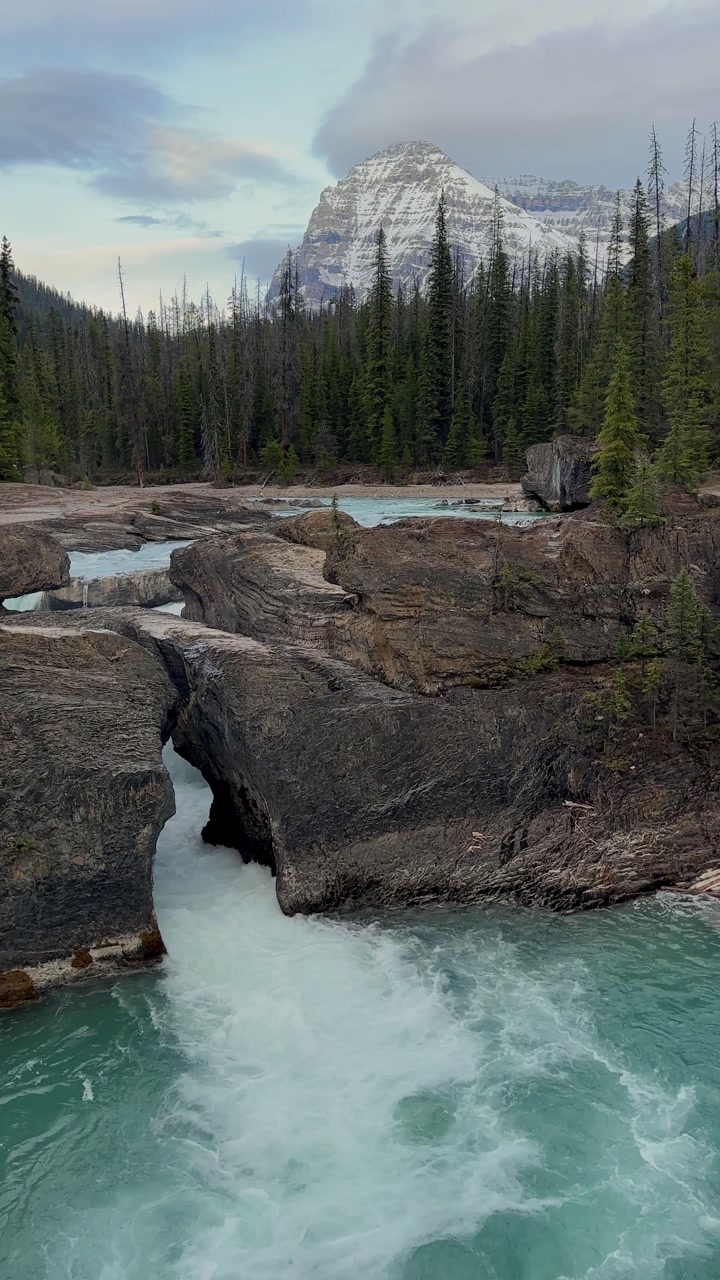 Turquoise water rushing through Natural Bridge lower falls in Yoho national park