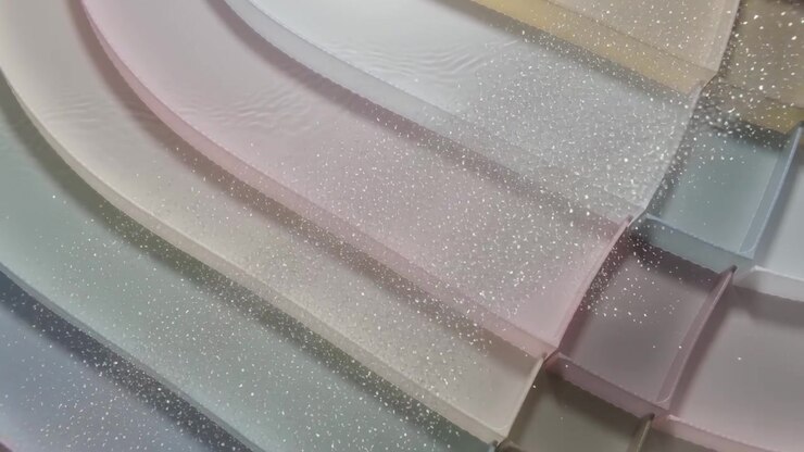 Entering from lower-left clear glitter sheet pressing into pastel ridges on table leaving fine dust