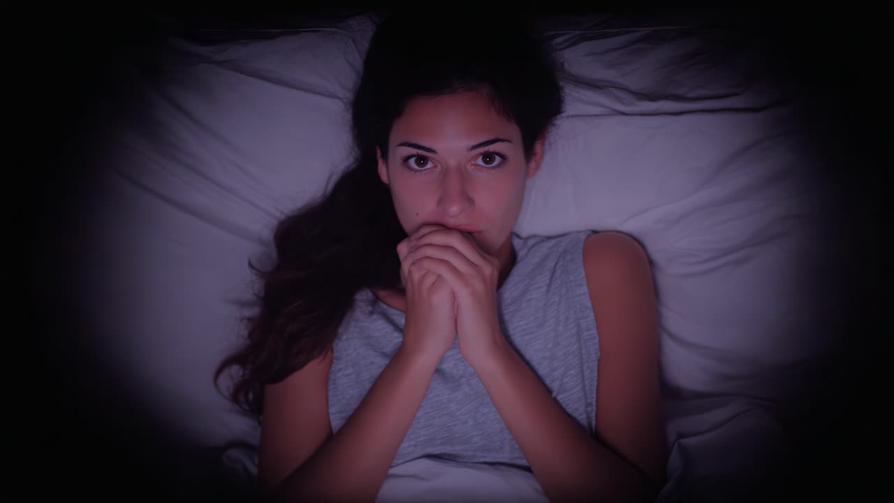 A Deep Emotional Struggle: The Intense Expressions of a Woman in Bed Battling Inner Demons and Anxiety while Trying to Find Peace in Darkness