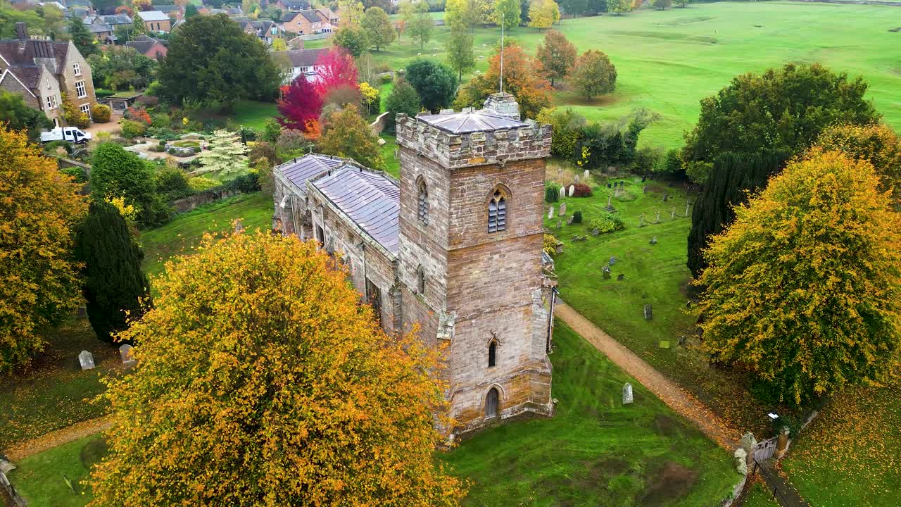 Aerial drone footage of St Martin’s Church, Litchborough, Towcester, capturing its historic charm amid vibrant autumn foliage and peaceful English countryside scenery